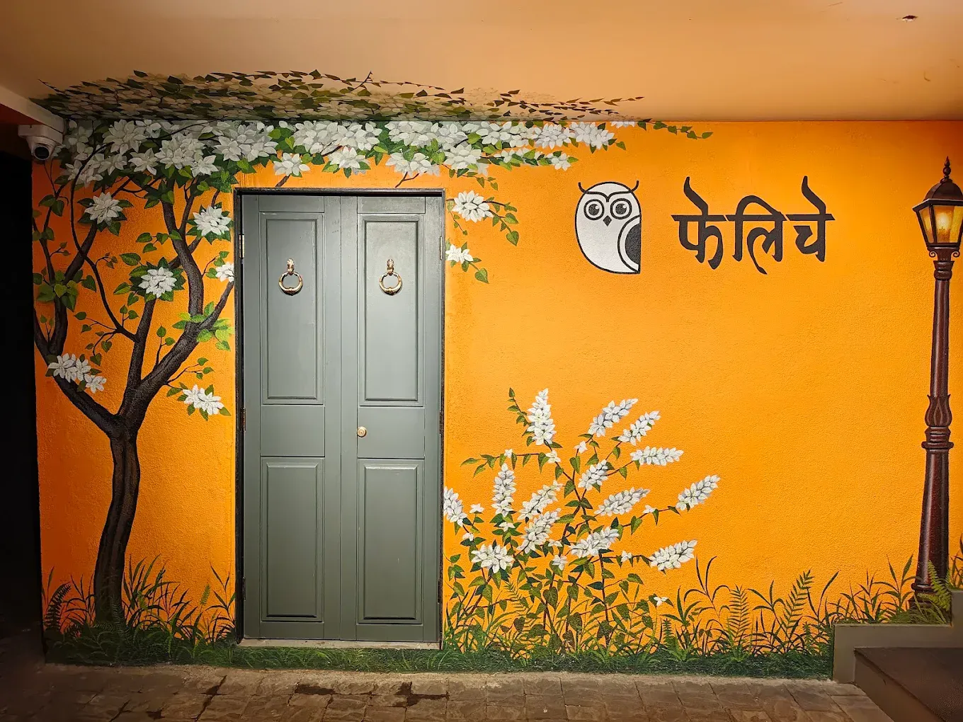 A painted door mural at the new outlet with the Felice owl and the name in Devanagari